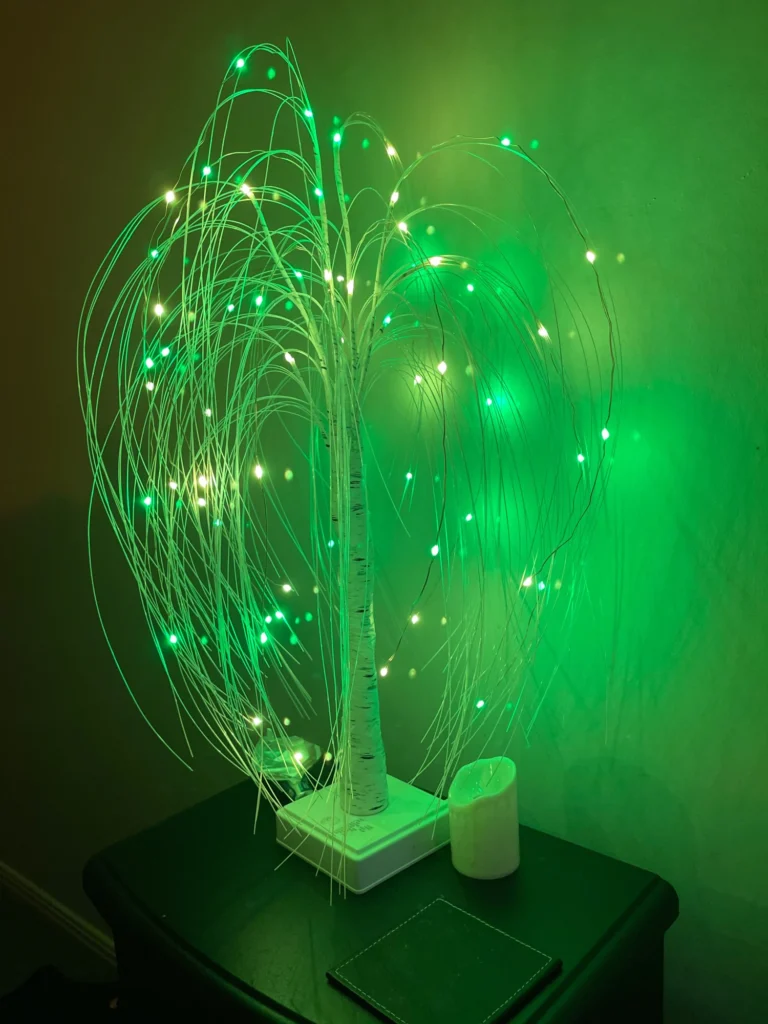 A green LED tree on a table in a dark room.